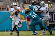 Raiders quarterback Derek Carr (4) looks to escape pressure from Jacksonville Jaguars linebacke ...