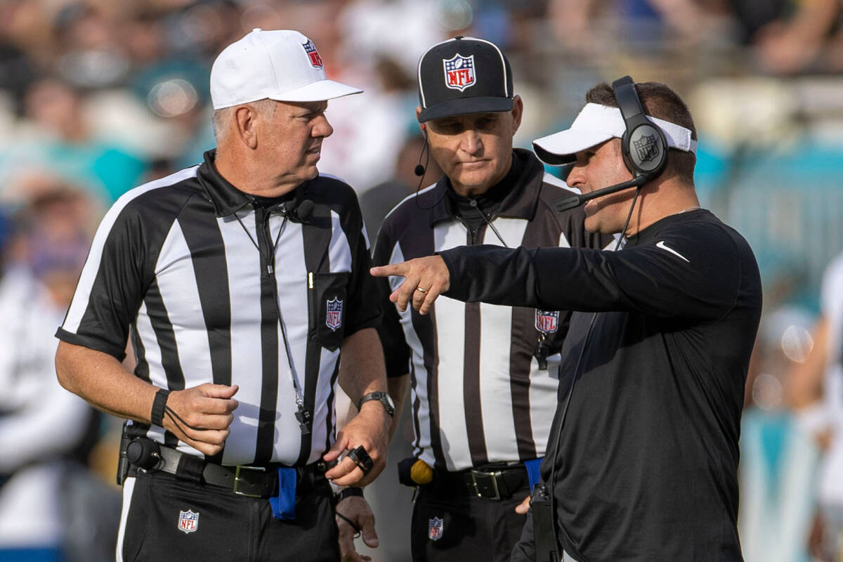Raiders head coach Josh McDaniels speaks to referees after a flag was thrown during the second ...