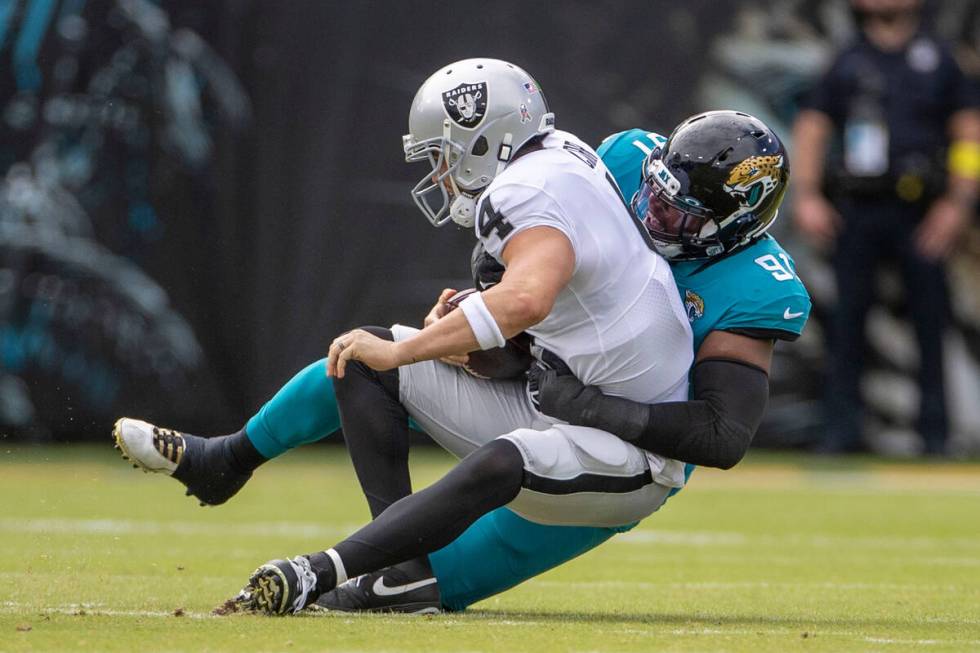 Raiders quarterback Derek Carr (4) is sacked by Jacksonville Jaguars defensive end Dawuane Smoo ...