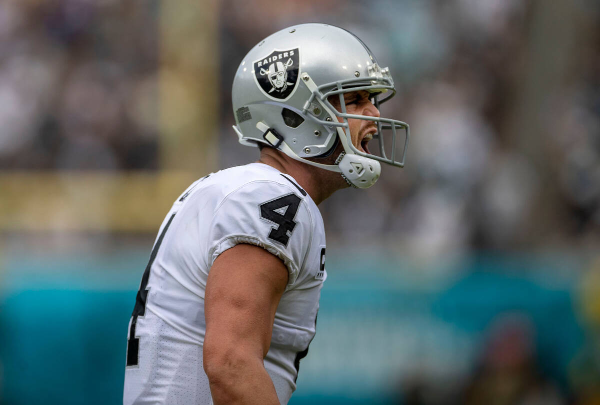 Raiders quarterback Derek Carr (4) shouts to fire up fans after Raiders wide receiver Davante A ...