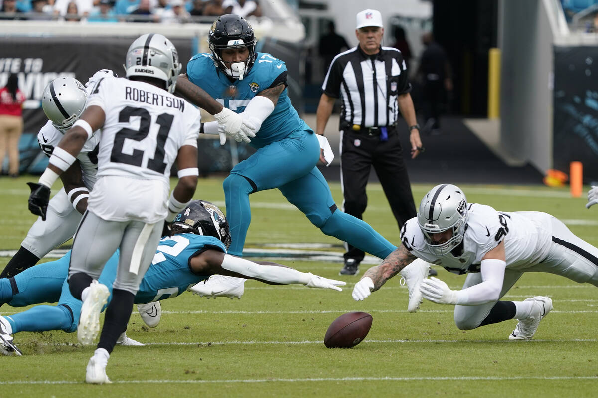 Las Vegas Raiders defensive end Maxx Crosby, right, recovers a fumble as Jacksonville Jaguars r ...