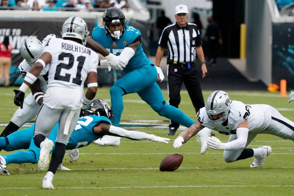 Las Vegas Raiders defensive end Maxx Crosby, right, recovers a fumble as Jacksonville Jaguars r ...