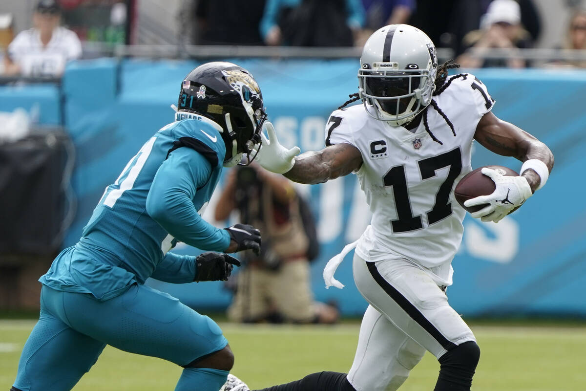 Las Vegas Raiders wide receiver Davante Adams (17) tries to get past Jacksonville Jaguars corne ...