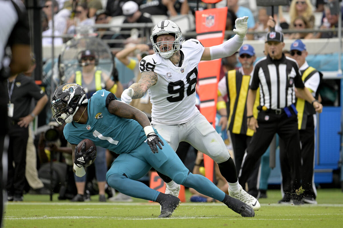 Las Vegas Raiders defensive end Maxx Crosby (98) stops Jacksonville Jaguars running back Travis ...