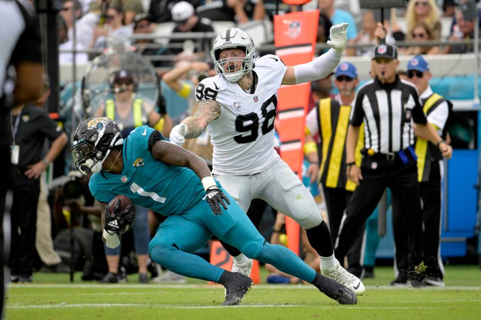 Las Vegas Raiders defensive end Maxx Crosby (98) stops Jacksonville Jaguars running back Travis ...