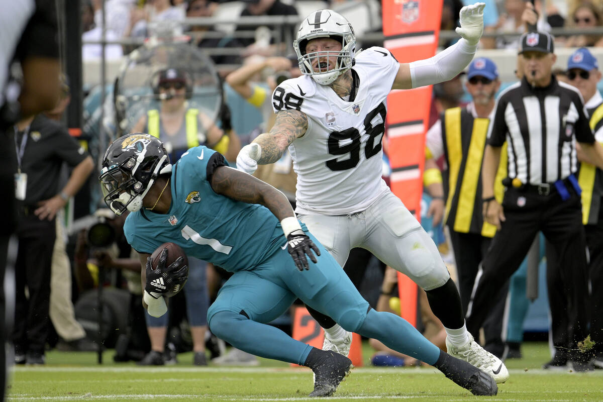 Las Vegas Raiders defensive end Maxx Crosby (98) stops Jacksonville Jaguars running back Travis ...