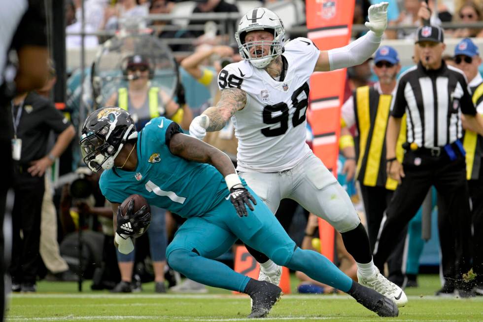 Las Vegas Raiders defensive end Maxx Crosby (98) stops Jacksonville Jaguars running back Travis ...