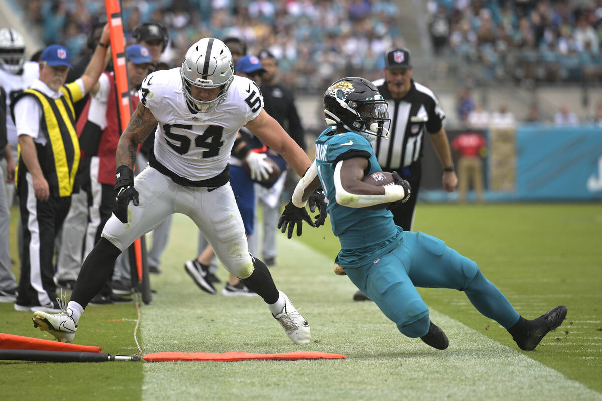 Jacksonville Jaguars running back Travis Etienne Jr., right, is pushed out of bounds by Las Veg ...