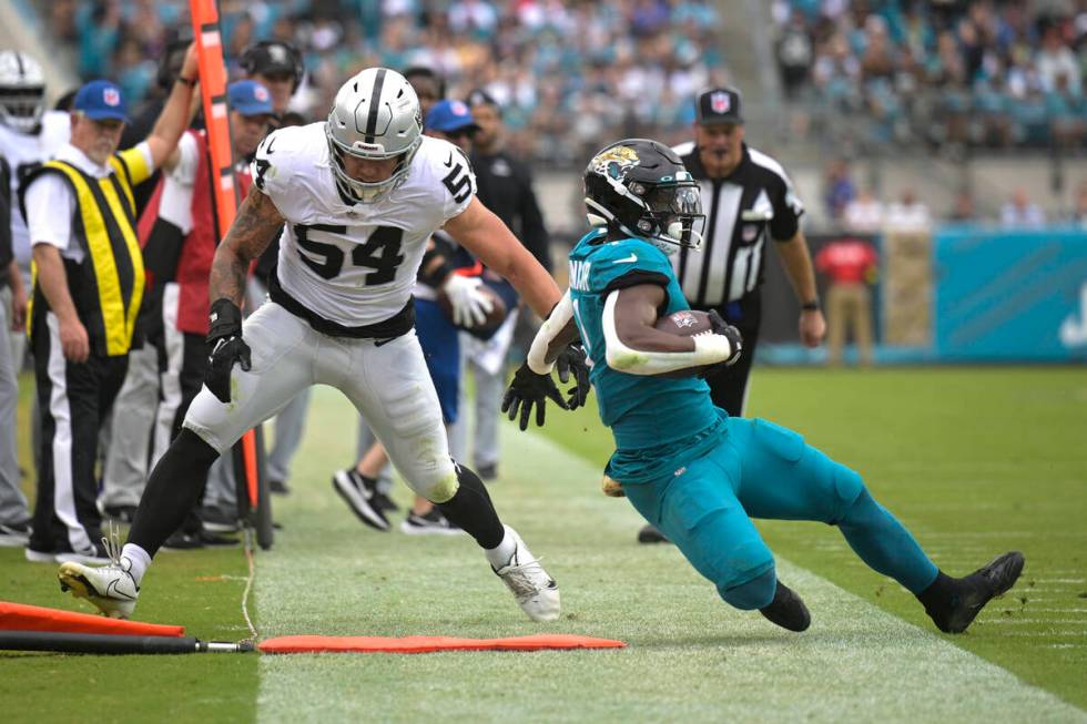 Jacksonville Jaguars running back Travis Etienne Jr., right, is pushed out of bounds by Las Veg ...