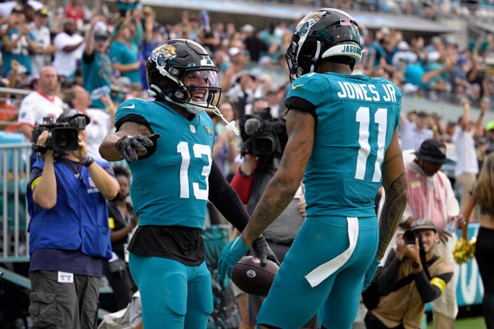 Jacksonville Jaguars wide receiver Christian Kirk (13) celebrates with Marvin Jones Jr. (11) af ...