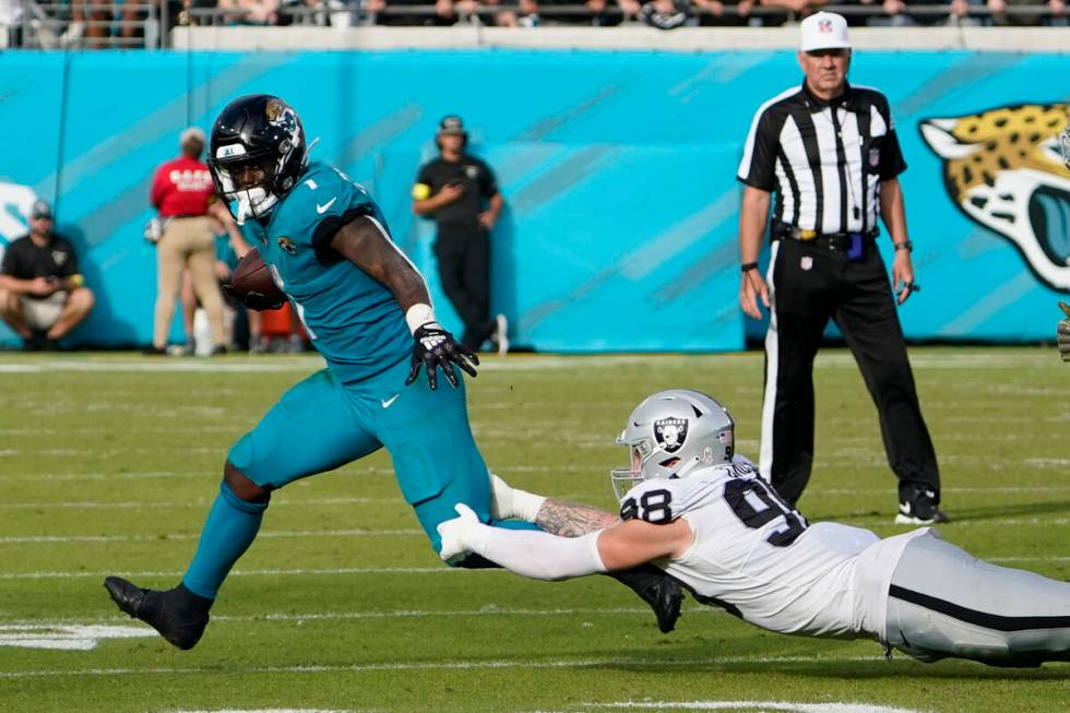 Jacksonville Jaguars running back Travis Etienne Jr. (1) gets past the reach of Las Vegas Raide ...