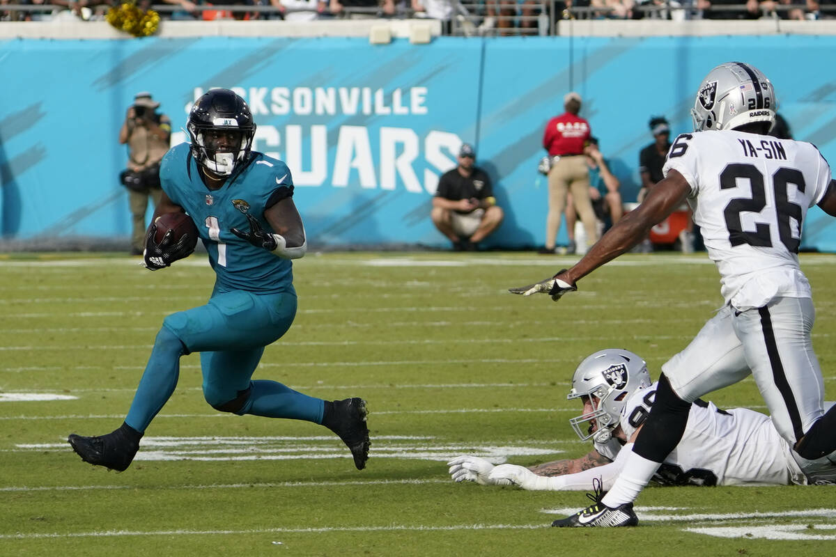 Jacksonville Jaguars running back Travis Etienne Jr. (1) gets past Las Vegas Raiders defensive ...