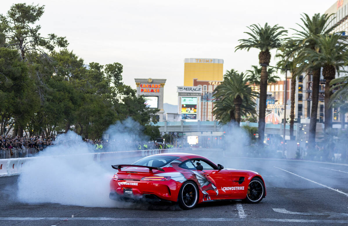 Racer Lewis Hamilton tests the track with doughnuts in a Mercedes before racing down the Strip ...