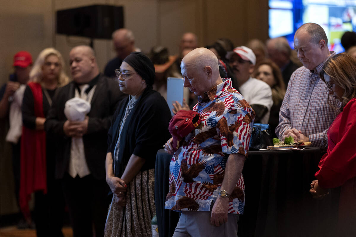 Attendees bow their heads in prayer during a GOP midterm election results watch party at Red Ro ...