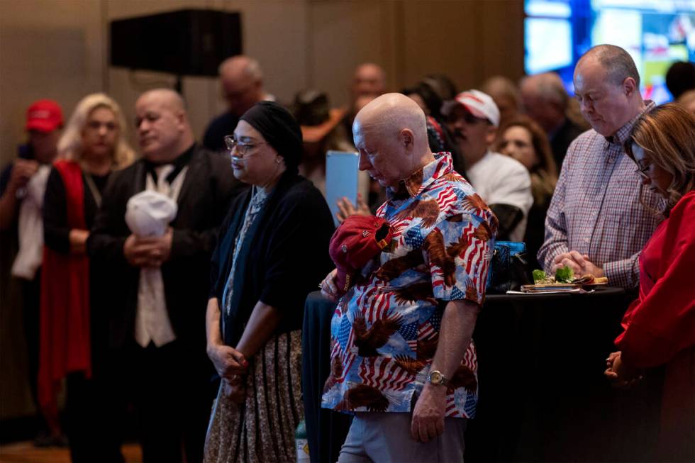 Attendees bow their heads in prayer during a GOP midterm election results watch party at Red Ro ...