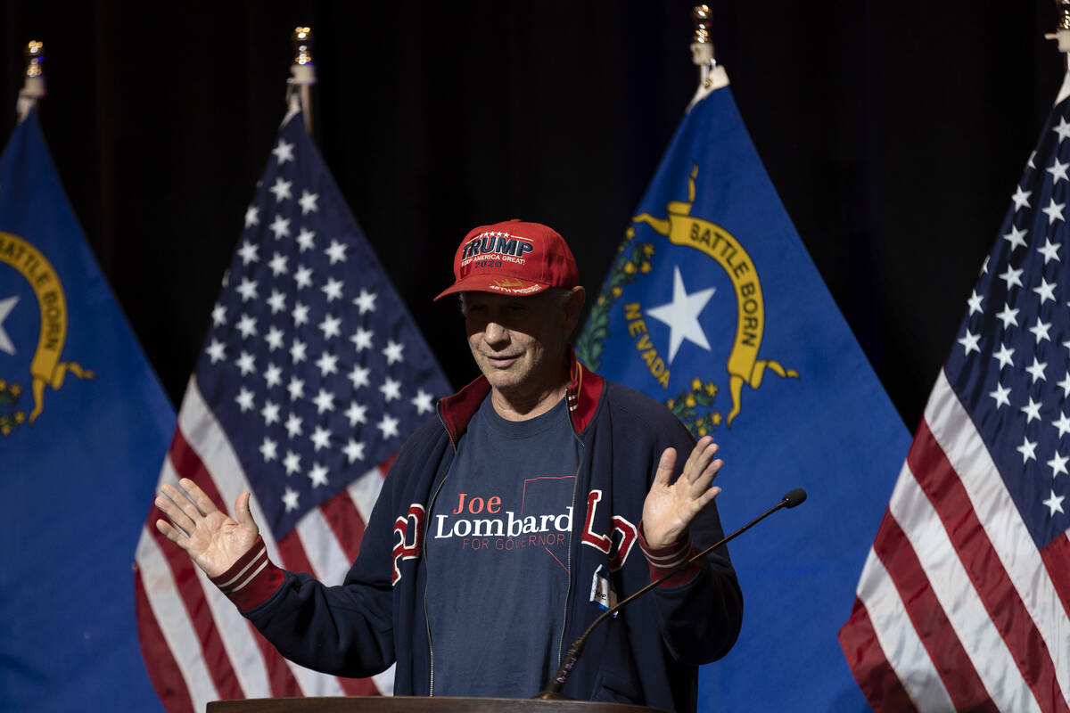 An attendee steals the podium for a photo during a GOP midterm election results watch party at ...