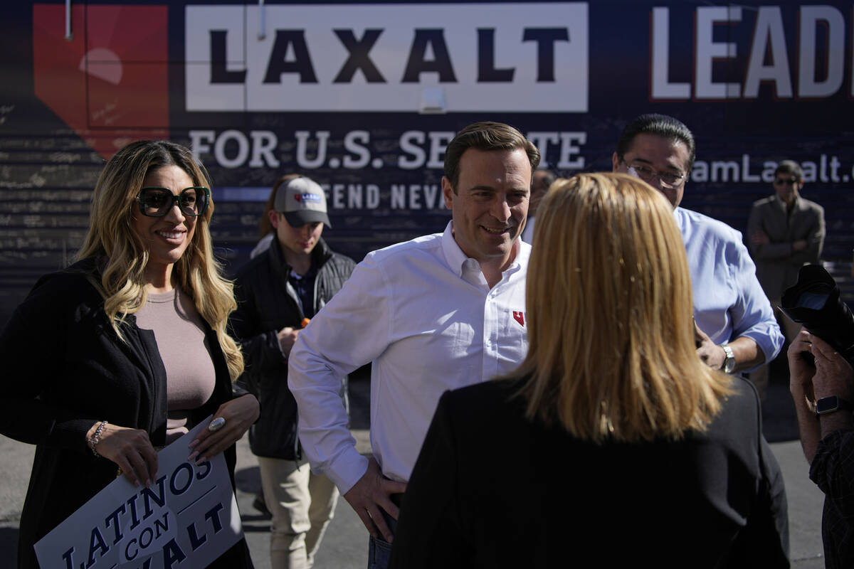 Nevada Republican Senate candidate Adam Laxalt, center, meets with supporters at a campaign sto ...