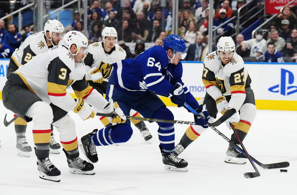 Toronto Maple Leafs forward David Kampf (64) carries the puck between Vegas Golden Knights defe ...