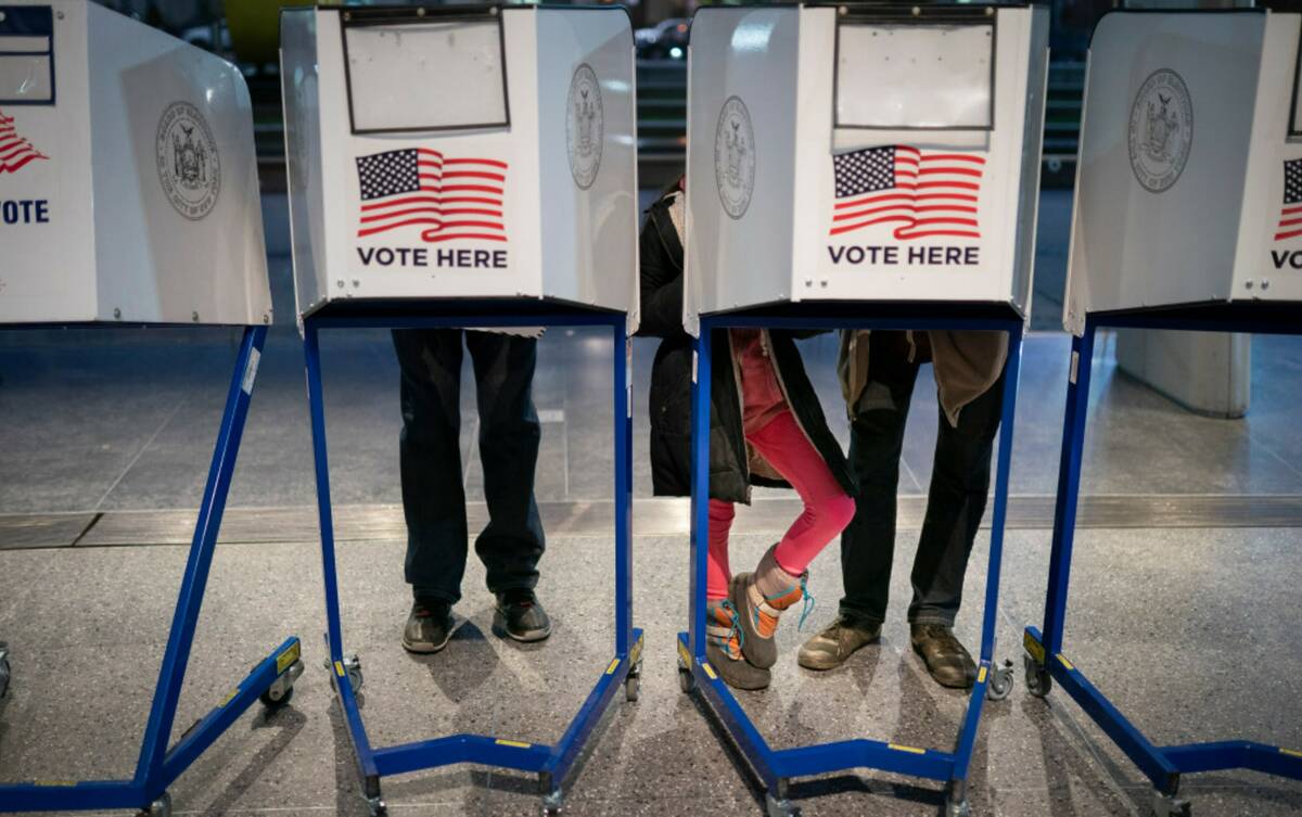 Voters fill out their ballots before bringing them to counting machines at a polling site in th ...