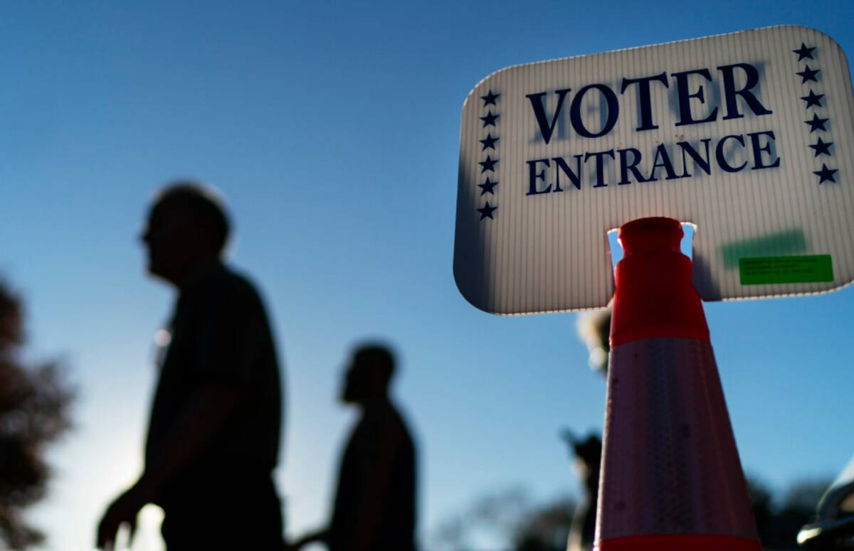 Voters pass a sign outside a polling site in Warwick, R.I., Monday, Nov. 7, 2022, after casting ...