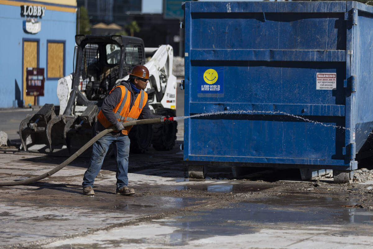A demolition crew member sprays water on the former site of the Travelodge motel on the Strip, ...