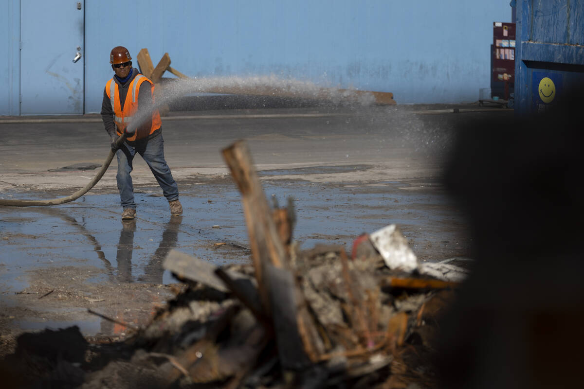 A demolition crew member sprays water on the former site of the Travelodge motel on the Strip, ...