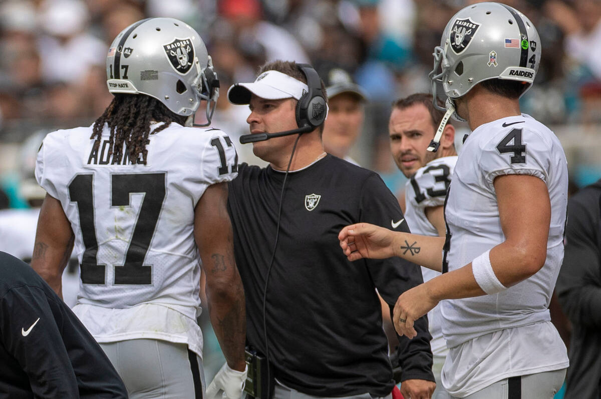 Raiders head coach Josh McDaniels speaks to wide receiver Davante Adams (17) on the sideline wi ...