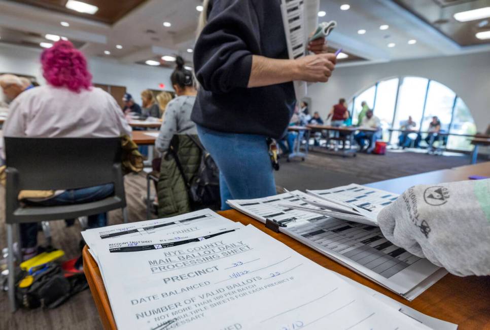 Stacks of counted ballots are separated as volunteers resume hand counting ballots in Nye Count ...