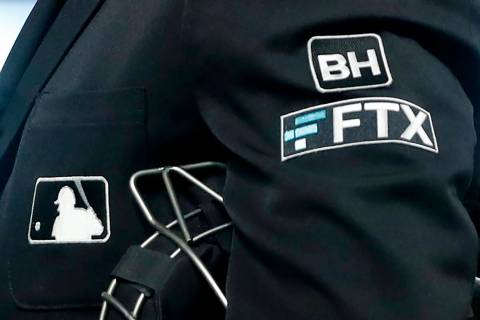 File - The FTX logo appears on home plate umpire Jansen Visconti's jacket at a baseball game wi ...