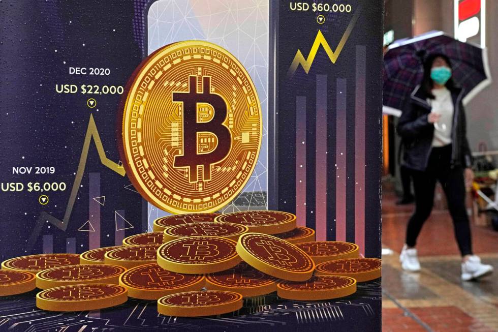 FILE - An advertisement for Bitcoin cryptocurrency is displayed on a street in Hong Kong, on Fe ...