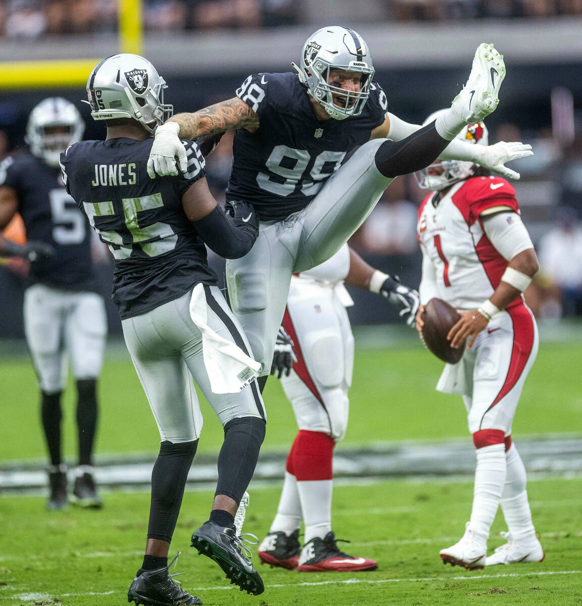Raiders defensive end Maxx Crosby (98) celebrates a sack with defensive end Chandler Jones (55) ...