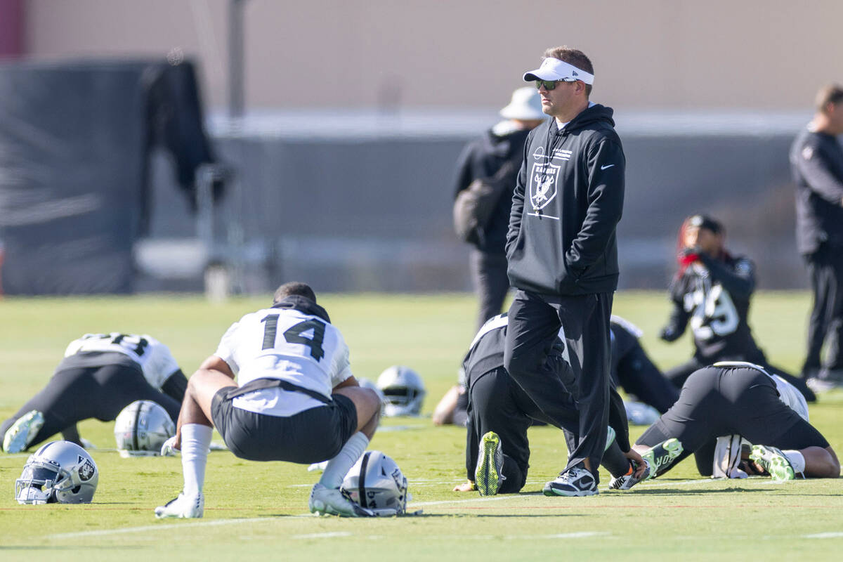 Raiders head coach Josh McDaniels walks through the team’s stretching period during prac ...