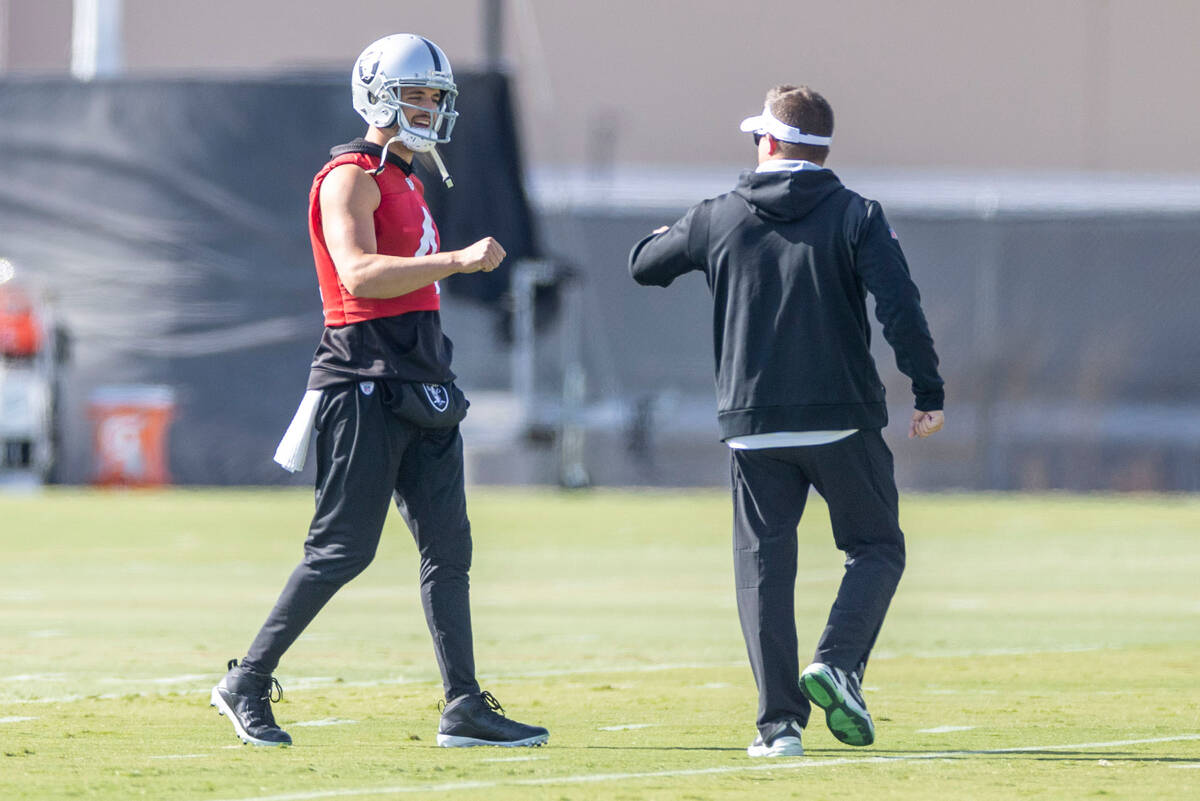 Raiders quarterback Derek Carr (4) greets Raiders head coach Josh McDaniels during practice at ...