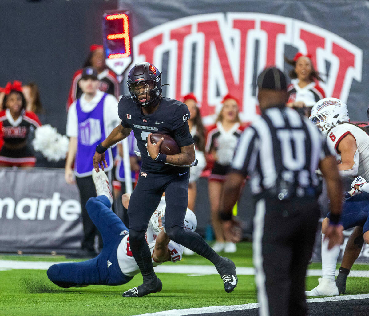 UNLV Rebels quarterback Doug Brumfield (2) eyes the end zone evading a tackle by Fresno State B ...