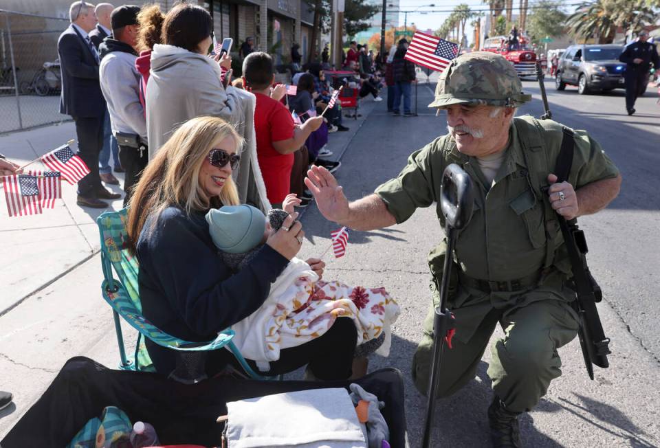 Robert Davison greets Nancy Escobedo and her daughter Maristella, 9 months, during the Veterans ...