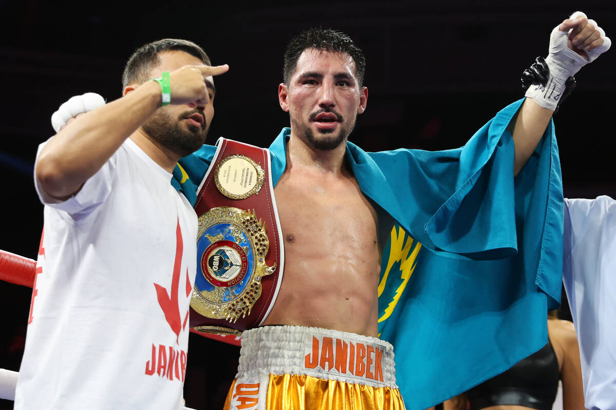 Janibek Alimkhanuly, center, raises his hand in victory after his unanimous decision win agains ...