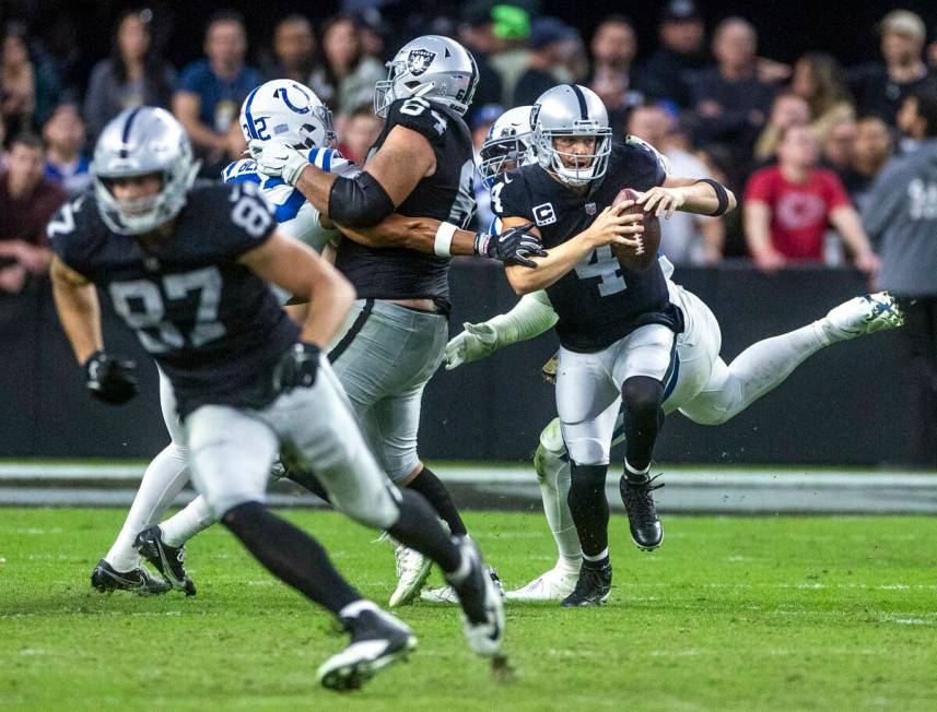 Raiders quarterback Derek Carr (4)nis grabbed in the pocked by Indianapolis Colts defensive end ...