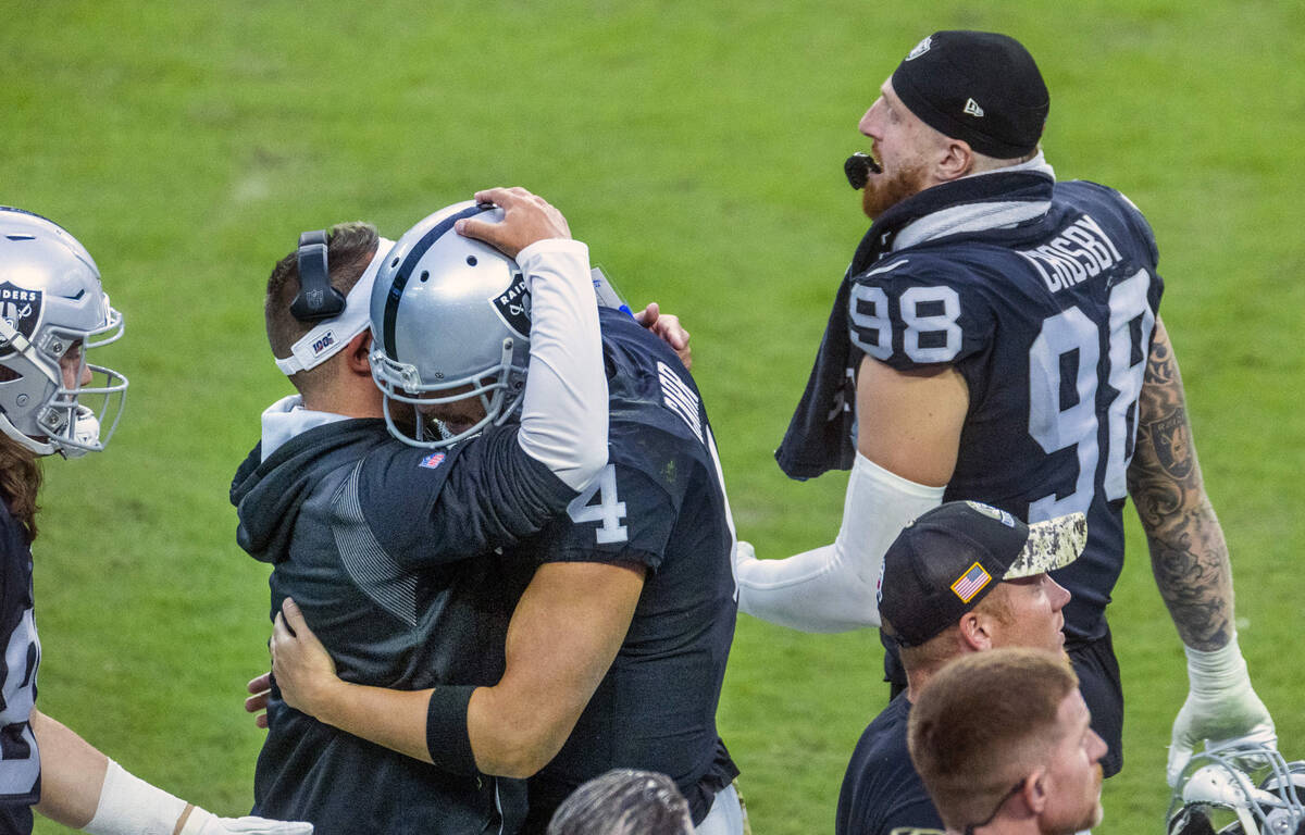 Raiders Head Coach Josh McDaniels embraces quarterback Derek Carr (4) on the sidelines versus t ...