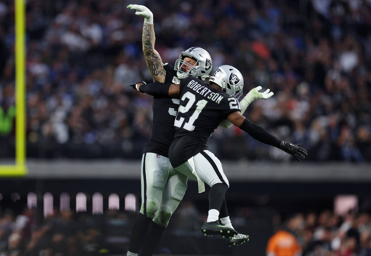 Raiders defensive end Maxx Crosby (98), with cornerback Amik Robertson (21), reacts after makin ...