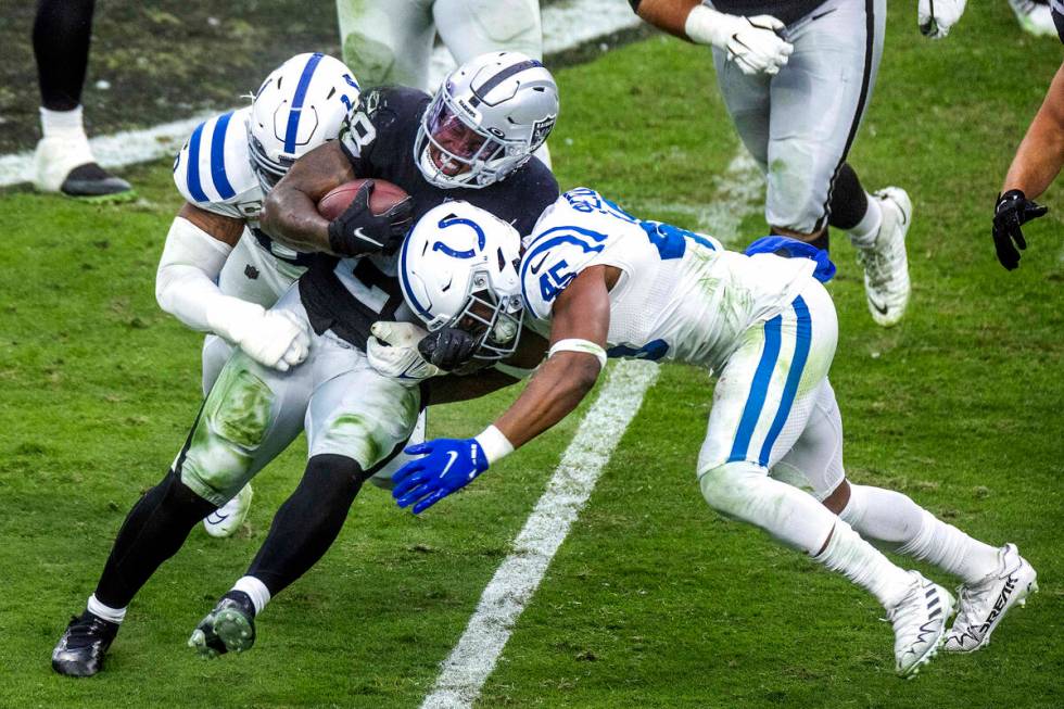 Raiders running back Josh Jacobs (28) drives for more yards while taking on Indianapolis Colts ...