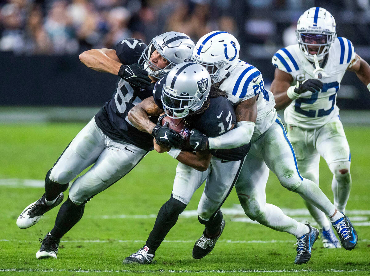 Raiders wide receiver Davante Adams (17) drives for more yards after a catch with help from tea ...