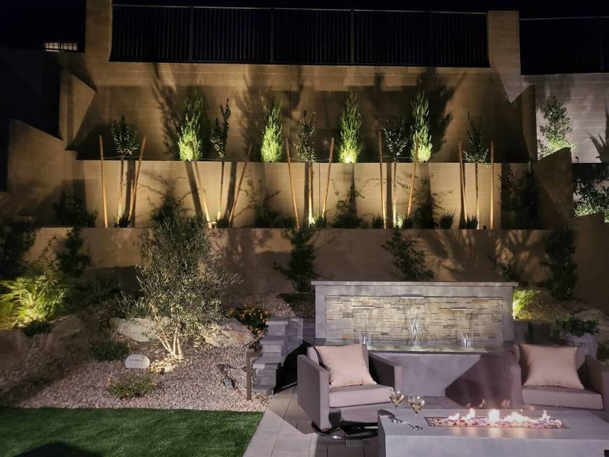 Chris Mauri, owner of Mauri Landscapes, incorporated raised planters and a water wall along the ...