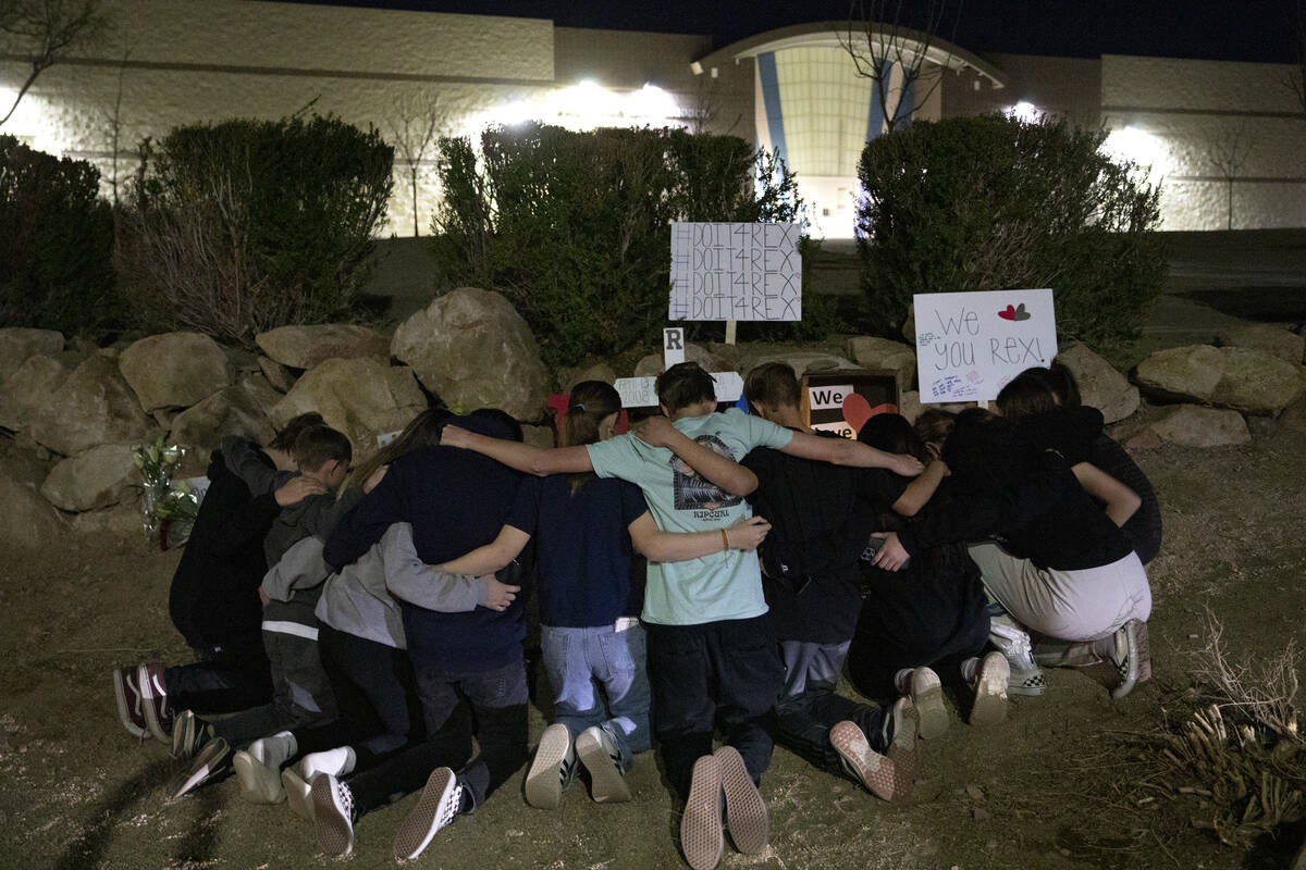 A group of neighborhood friends pose for a photo in front of a memorial at the scene where teen ...