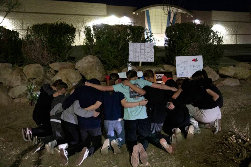 A group of neighborhood friends pose for a photo in front of a memorial at the scene where teen ...