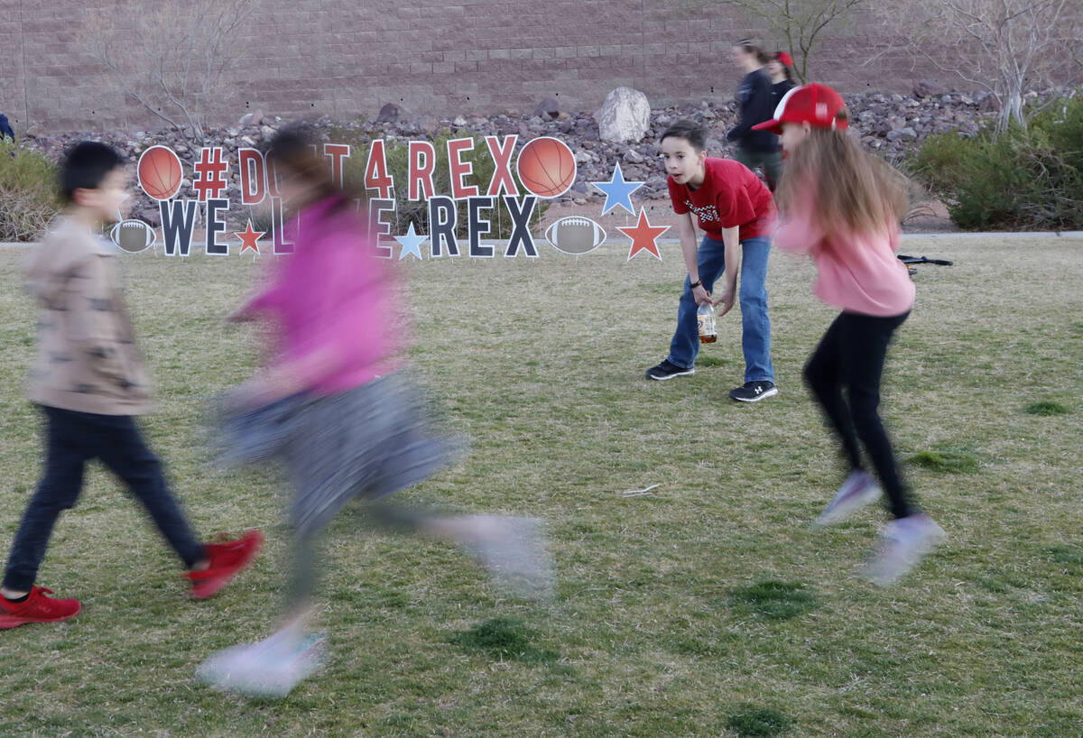 Children play around a sign for Rex Patchett , Friday, March 11, 2022, during a remembrance ce ...