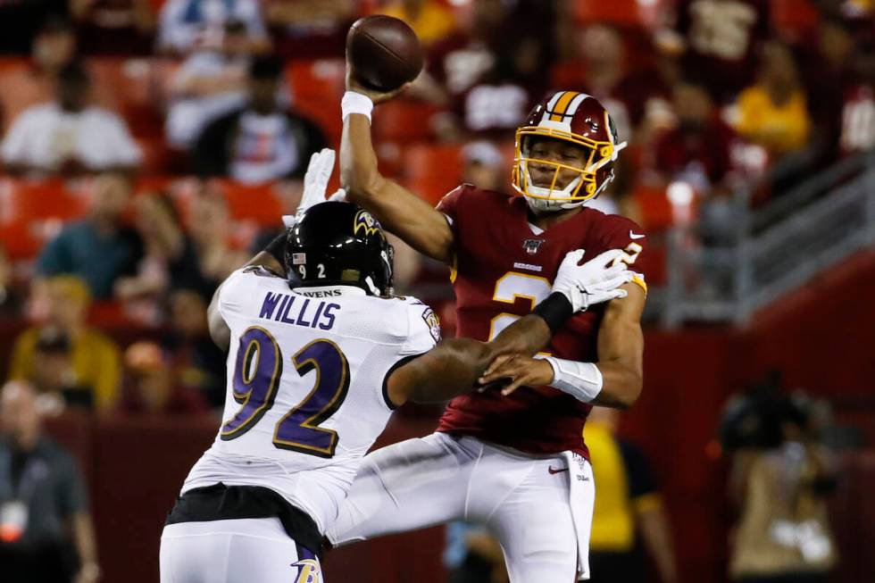 Washington Redskins quarterback Jalan McClendon (2) gets the pass off as he is hit by Baltimore ...