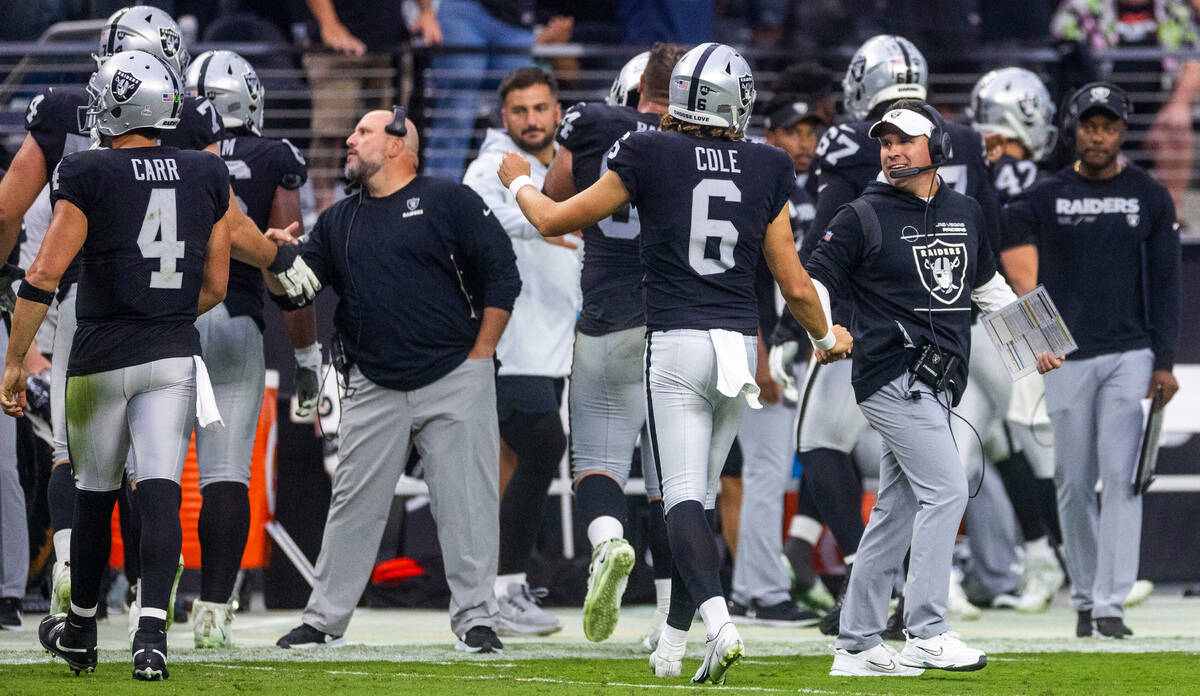 Raiders Head Coach Josh McDaniels congratulates punter AJ Cole (6) on another successful field ...