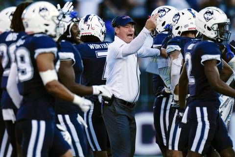 Connecticut head coach Jim Mora singles to players during the second half of an NCAA college fo ...