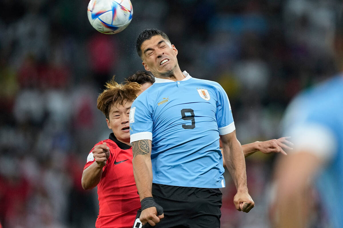 Uruguay's Luis Suarez, right, and South Korea's Kim Jin-su go for a header during the World Cup ...