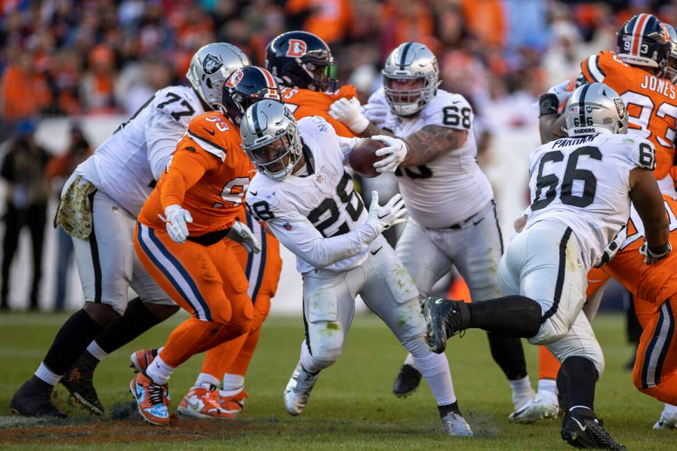 Raiders running back Josh Jacobs (28) looks for room to run against the Denver Broncos during t ...